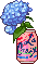 A la croix can with a hydraenga flower in it.